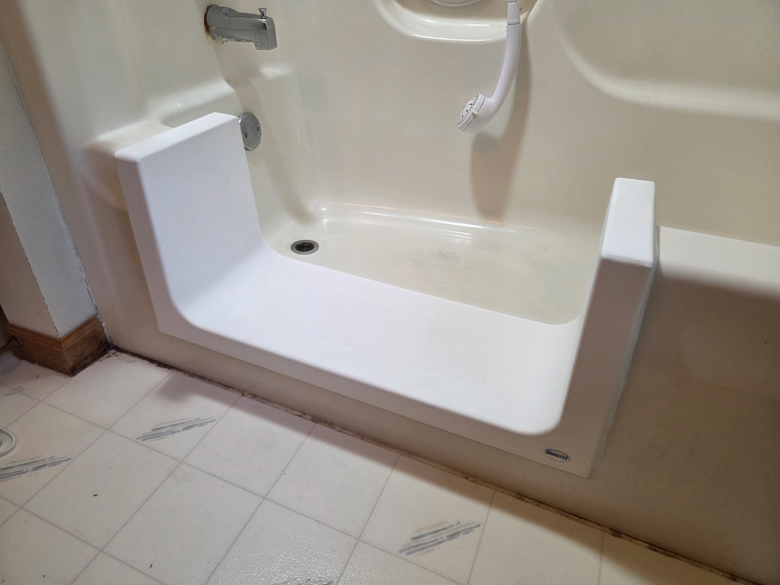The Deep Step conversion with a wide low opening in an existing cream-colored bathtub